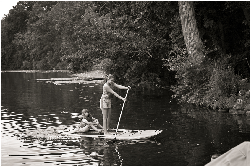 Two children paddle a kayak in a Michigan lake